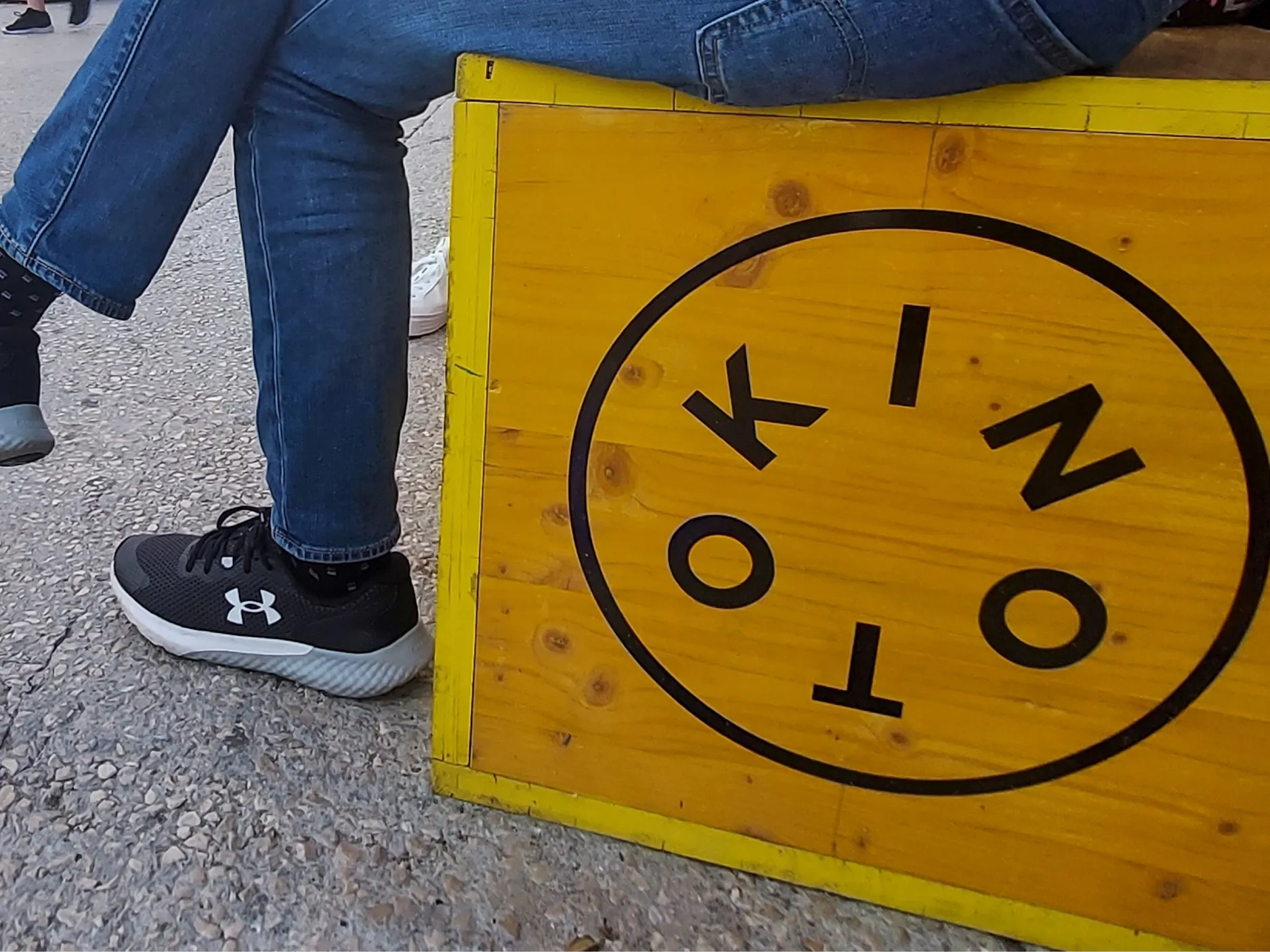 Lesen boks z logom Kino Otoka, na njem nekdo sedi